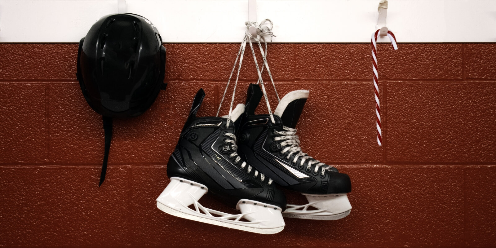 hockey skates hanging between helmet and candy cane