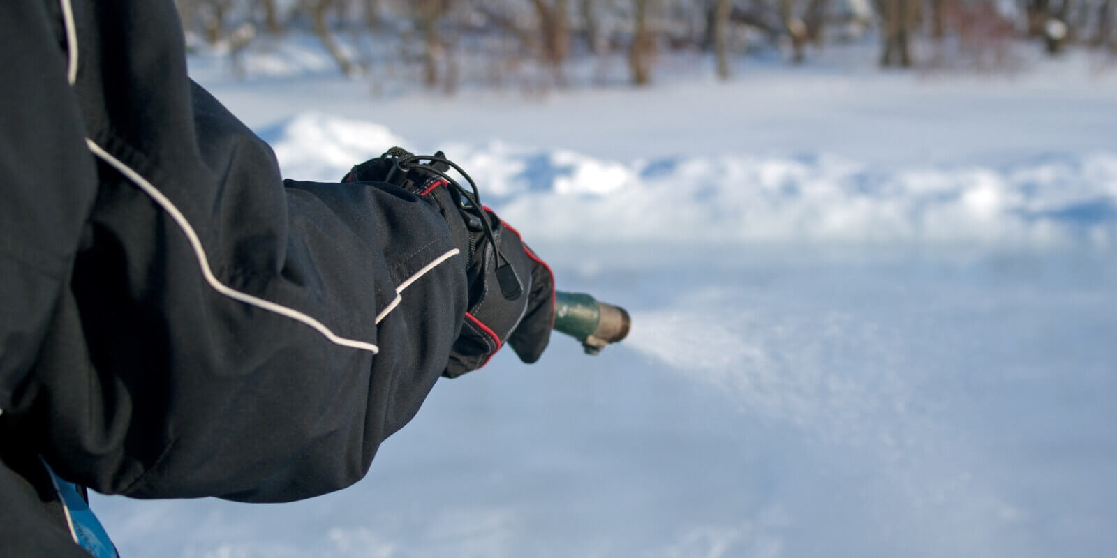 a person flooding an ice rink with a hose